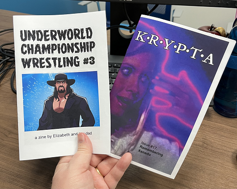 hand holding copies of Underworld Championship Wrestling #3 and KRYPTA #2